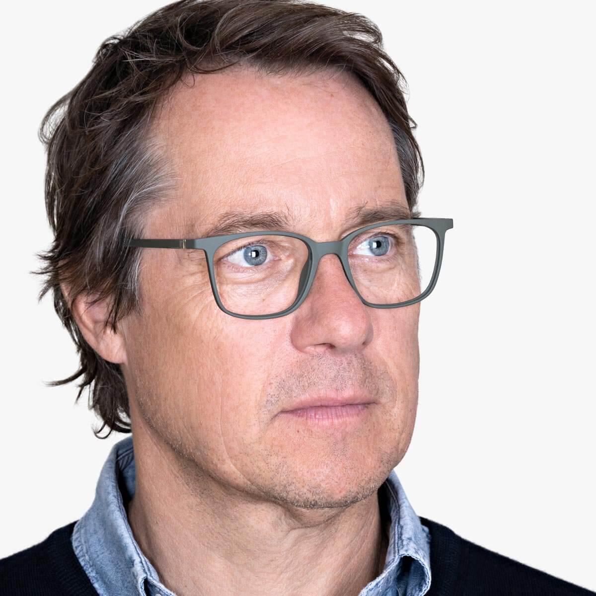 Person wearing Fyn Dark Army glasses with a matte green finish