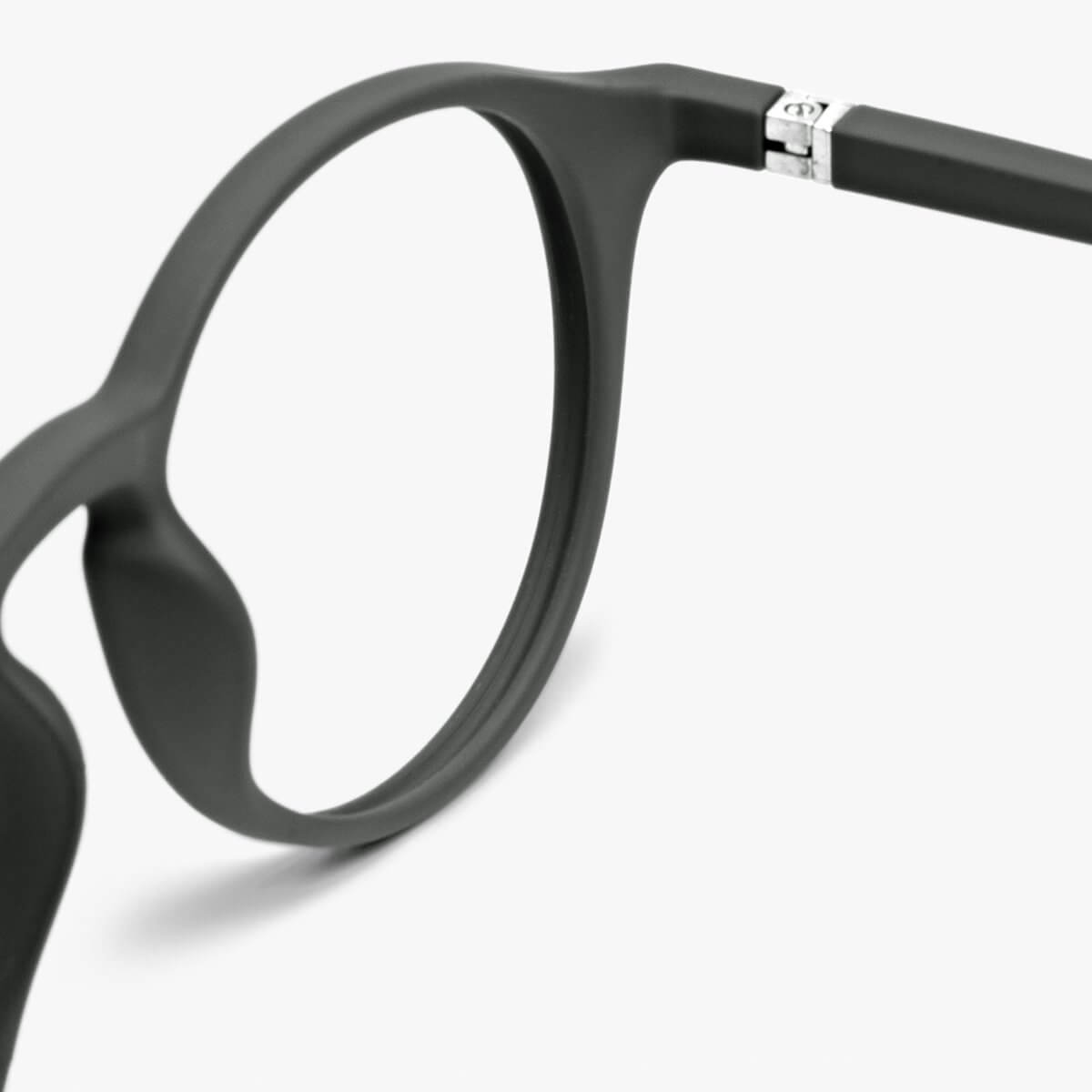 Close-up of matte black glasses frame with silver hinge